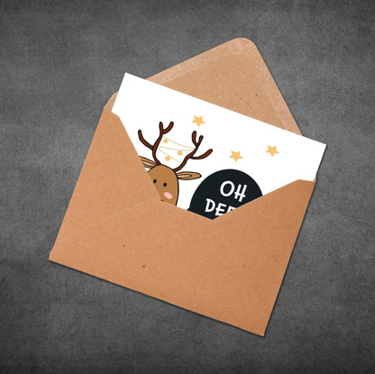 Card with a reindeer illustration and 'Oh Deer!' text inside an open brown envelope on a dark gray background.