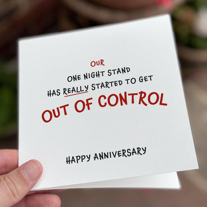 Card with humorous text about an anniversary, held by a hand.