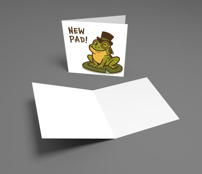 Greeting card with a frog wearing a top hat and monocle, and 'New Pad!' text on a gray background.