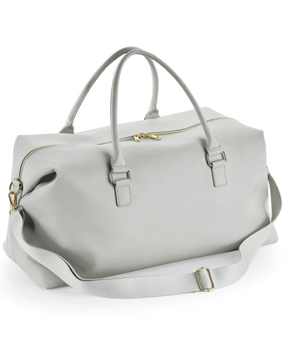 Light gray duffel bag with gold hardware on a white background