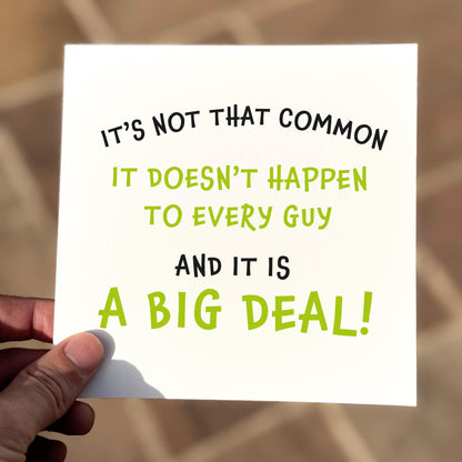 Hand holding a card with motivational text on a blurred background