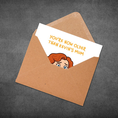 Card with cartoon character and text 'You're now older than Kevin's mum' in an open brown envelope on a dark background