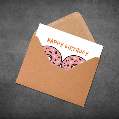 Happy Birthday card with donut illustrations in a brown envelope on a dark gray background