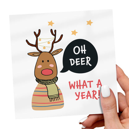 Card with a reindeer illustration and text 'Oh Deer What a Year!' held by a hand.
