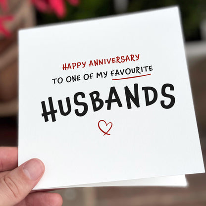 Card with 'Happy Anniversary to one of my favourite husbands' text held by a hand.