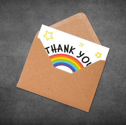 Brown envelope with a 'Thank You' card featuring a rainbow and stars on a dark gray background