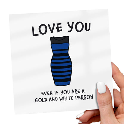 Card with a blue and black striped dress illustration and text, held by a hand.
