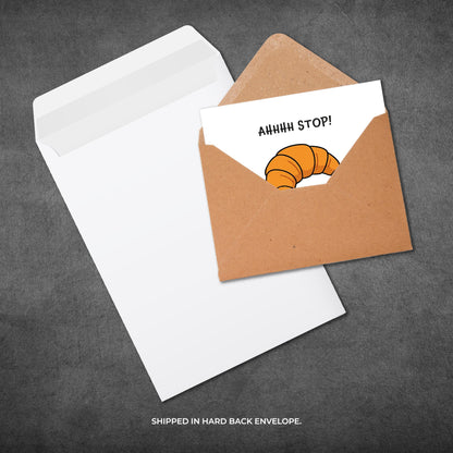 Card with a croissant illustration and text 'AHHHH STOP!' in a brown envelope on a gray background.