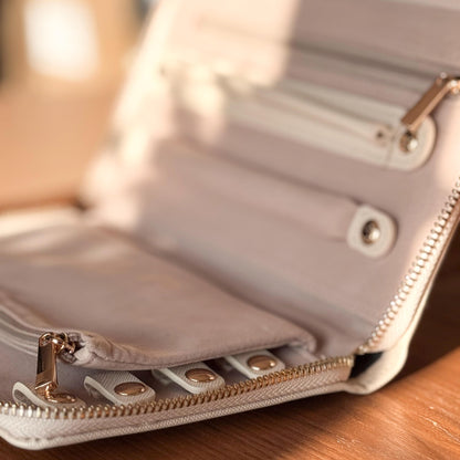 Close-up of a beige wallet with gold accents on a wooden surface