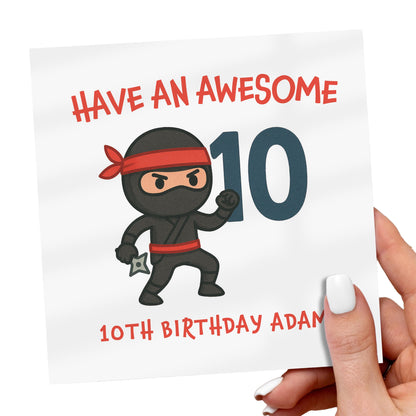 Birthday card with a cartoon ninja holding the number 10, held by a hand.