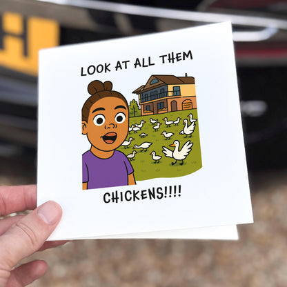 Card with a cartoon illustration of a girl and chickens, held by a hand.