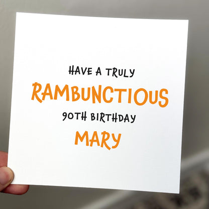 Handwritten birthday card with personalized message held by a hand.