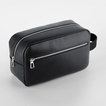 Black toiletry bag with silver zippers on a light gray background