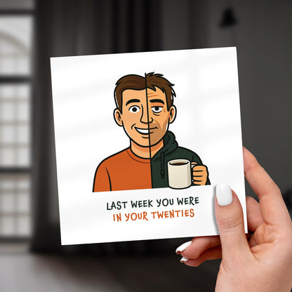 Card with cartoon illustration of a man holding a coffee cup and text, held by a hand.