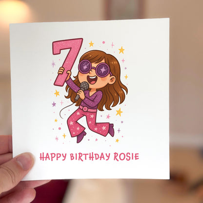 Birthday card with a cartoon character holding a microphone and the number 7, with 'Happy Birthday Rosie' text.
