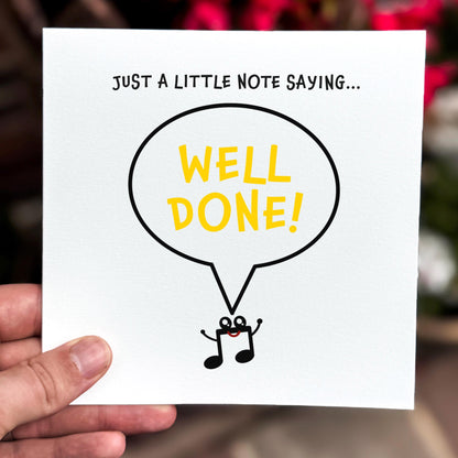 Hand holding a card with 'Well Done!' in a speech bubble on a white background