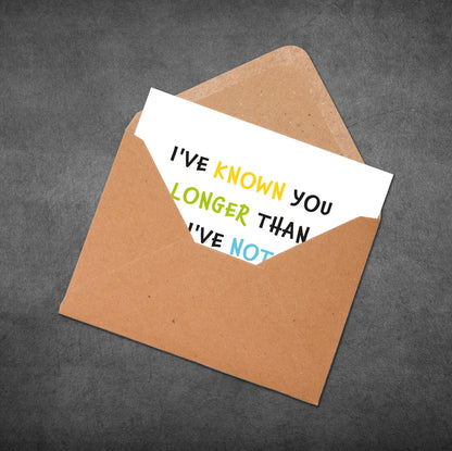 Open brown envelope with a white card inside displaying colorful text on a gray background