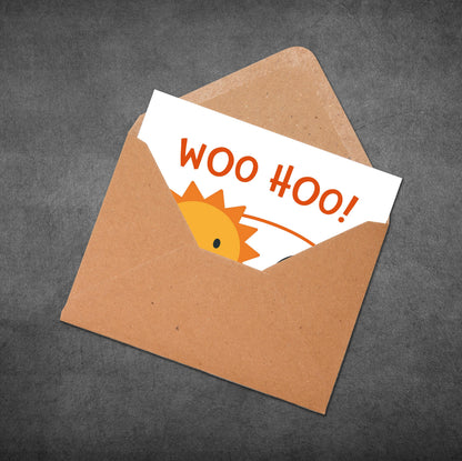 Brown envelope with a white card inside displaying 'WOO HOO!' text and a cartoon character on a dark gray background.