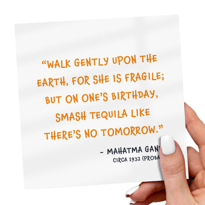 Hand holding a card with a humorous quote by Mahatma Gandhi on a white background