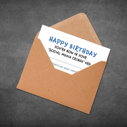 Brown envelope with a birthday card inside on a gray background