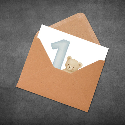 Brown envelope with a white card featuring a blue number '1' and a bear illustration on a gray background.