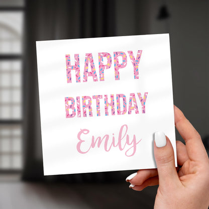 Hand holding a birthday card with 'Happy Birthday Emily' text