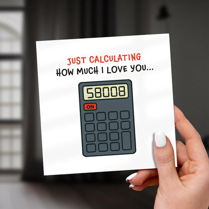 Card with a calculator graphic and text 'Just calculating how much I love you...' held by a hand.