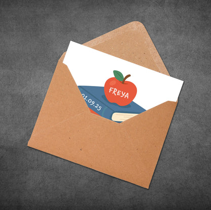 Envelope with a card featuring an apple illustration and text on a dark gray background