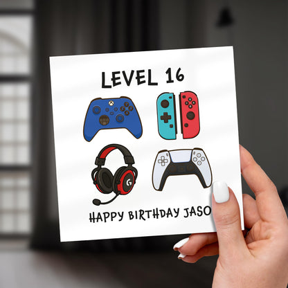 Hand holding a birthday card with gaming-themed illustrations and text.