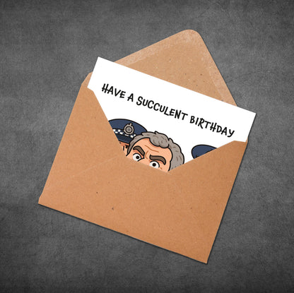 Greeting card with a cartoon character and 'Have a Succulent Birthday' text inside an open envelope on a dark background.