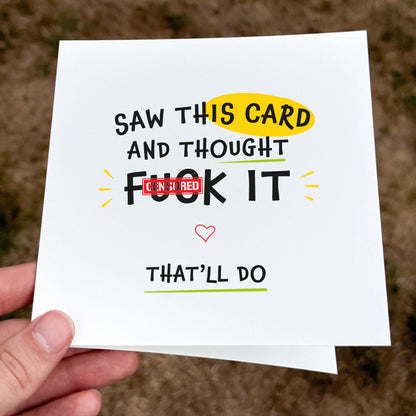 Card with humorous text held by a hand on a blurred background