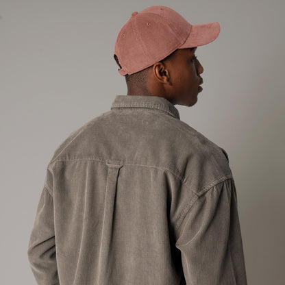 Person wearing a pink cap and gray shirt against a plain background