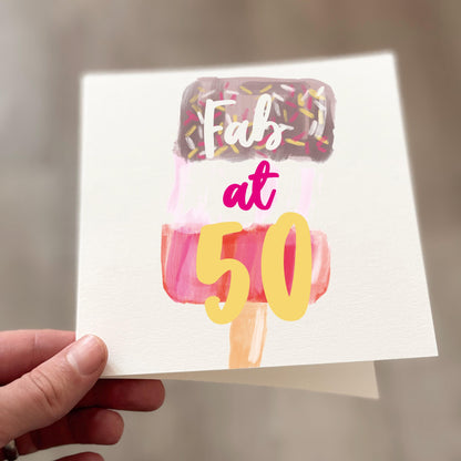 Greeting card with 'Fab at 50' text and ice cream cone design held by a hand.