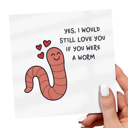 Card with a cartoon worm and text 'Yes, I would still love you if you were a worm' held by a hand.