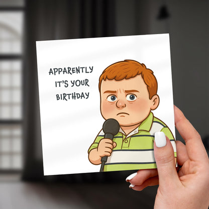 Card with cartoon boy holding a microphone and text 'Apparently it's your birthday' held by a hand.