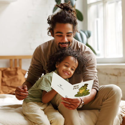 Man and child sitting together, reading a card with a frog illustration.