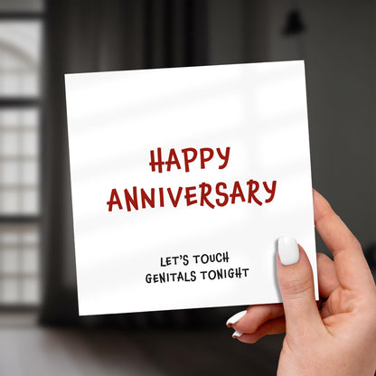 Hand holding a card with 'Happy Anniversary, let's touch genitals tonight' text.
