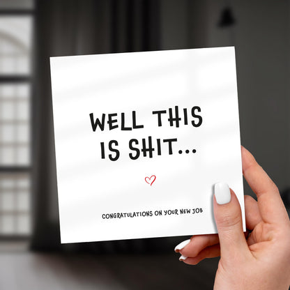 Hand holding a card with humorous text congratulating someone on a new job.