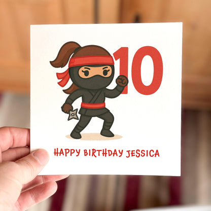 Birthday card with a cartoon ninja character and the number 10, held by a hand.