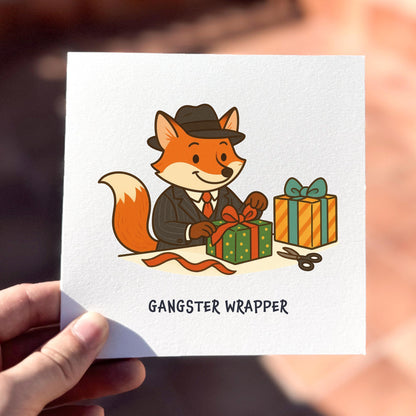 Card with a cartoon fox in a suit wrapping presents, labeled 'Gangster Wrapper'.