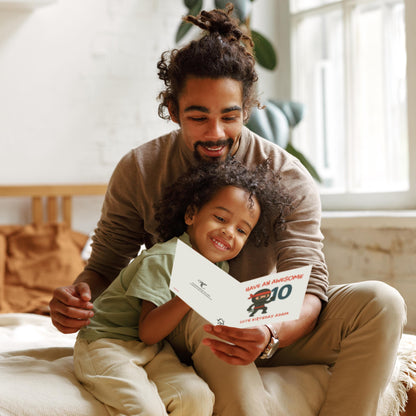 Man and child sitting together holding a birthday card in a cozy room.