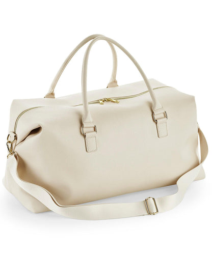 Beige duffel bag with gold zippers on a white background