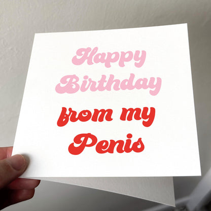 White card with pink and red text held by a hand against a neutral background