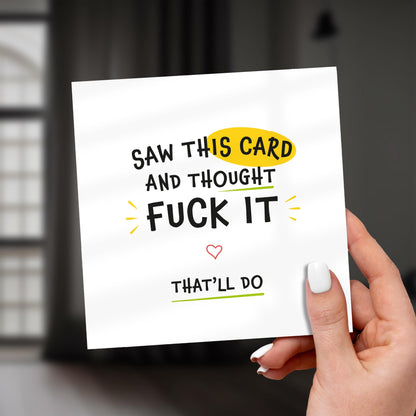 Card with humorous text held by a hand against a blurred background