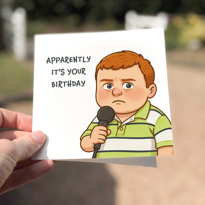 Cartoon character holding a microphone with text 'Apparently it's your birthday' held by a hand outdoors.