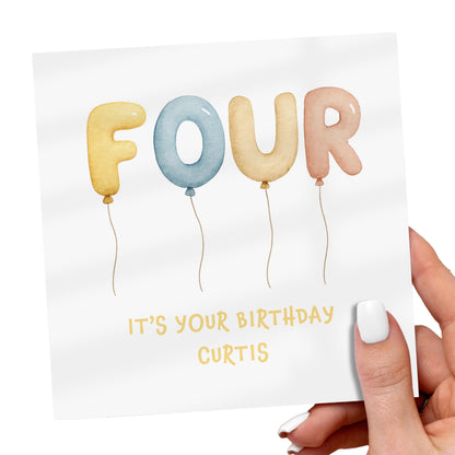 Hand holding a birthday card with colorful balloon letters spelling 'FOUR' and text 'It's your birthday Curtis'.