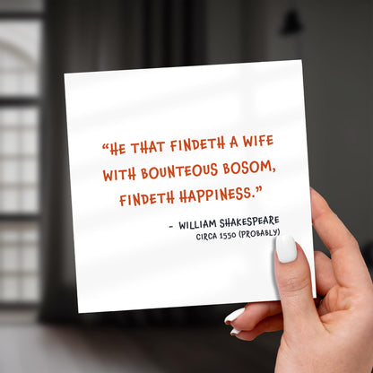 Hand holding a card with Shakespeare quote against a blurred background