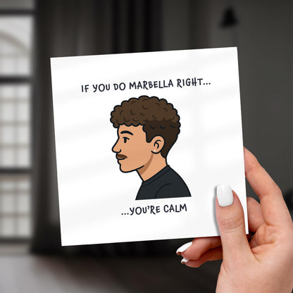 Hand holding a card with a cartoon illustration of a man and text on a blurred background
