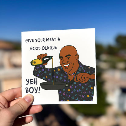 Card with a cartoon character holding a bottle of barbecue sauce and text, held by a hand outdoors.