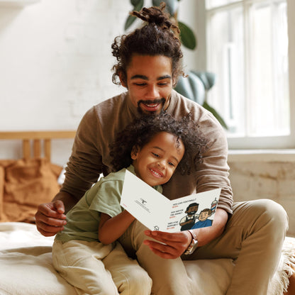 Man and child sitting together, looking at a photo album in a cozy room.